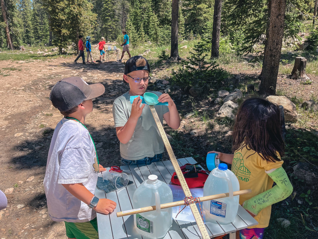 Campers assemble a waterballoon catapult for a camp activity in the mountains.