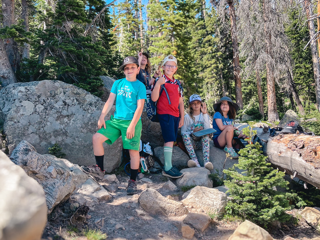 Campers sit on the rocks and eat lunch in the mountains.